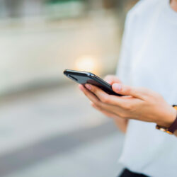 Woman hand using black smartphone. The concept of using the phone is essential in everyday life.